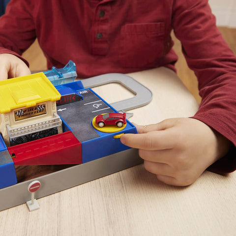 Child playing with Collapsible Racetrack Playset With 6 Mini Cars, 84-Piece Track Kit, showing a red mini car at the garage.