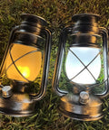 Bronze Outdoor LED Lantern With Vintage Flame Effect for garden and patio decor on grass showing realistic flicker and ambient glow.