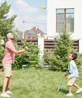 Father and son playing badminton in backyard with a 12 Pack Nylon Badminton Shuttlecocks For Backyard Fun And Outdoor Play in neon yellow.
