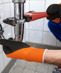 Person wearing 2 Pairs Waterproof Work Gloves For Men And Women CR3306 With Double Latex Coating, using wrench on pipe