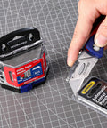 50 Pack Utility Knife Blades With Dispenser, Razor Sharp SK5 Steel Refills being used to cut packaging on work surface.