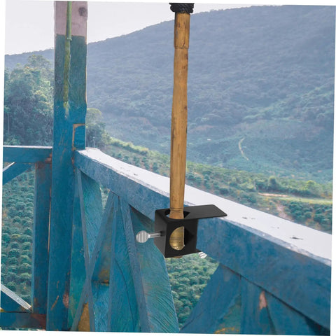 Heavy Duty Torch Clamp Holder Mount For Deck Lights And Tiki Torches On Porches Railings And Outdoor Spaces Durable Iron Clamp Mount Weatherproof Easy Install Ready To Rock For Patio Garden And Deck Party Lighting holding a torch on a blue railing overlooking a scenic view.