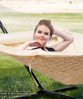 Woman relaxing on Two Person Outdoor Hammock Replacement Pad For Stand, Quilted Reversible Polyester Pad With Fiber Fill in beige.