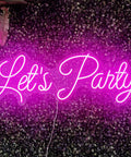 Pink "Let's Party" LED Neon Wall Sign against a leafy backdrop, 27 inch, suitable for weddings, birthdays, bars, and clubs.