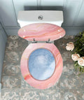 Round Resin Toilet Seat for Bathroom with pink and blue marble design, fittings attached, top view, suitable for various toilet models.