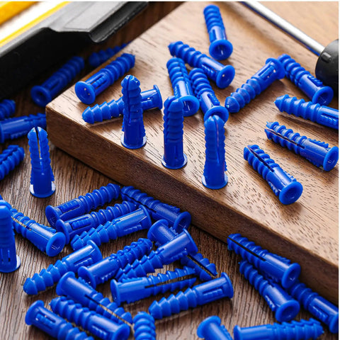 Blue 500 Pcs Plastic Drywall Anchors Ribbed Lightweight Hollow Walls Mounting Set scattered on brown wooden surface close-up view