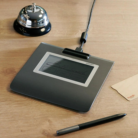Slick Low Profile Signature Pad With A Sharp 4.5 Inch Monochrome Screen Built For Hassle Free Digital Signing On Pc And Mac on a desk.