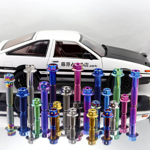 Assorted titanium bolts with flange hex heads in rainbow burnt colors displayed on a reflective surface