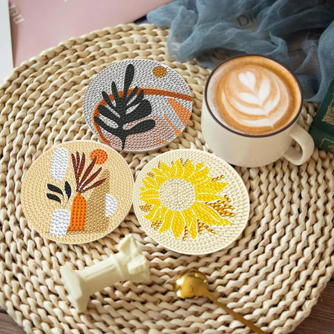 Three completed coasters from the Eight Pack Landscape Diamond Painting Coasters With Holder Complete DIY Kit For Adults Round Full Drill 5D Gem Dots Craft Set With Pen Glue Tray For Home Decor And Party Time displayed with a coffee cup.
