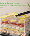 Straight Up Stainless Steel Food Dehydrator For Real Deal Jerky Drying And Heavy Duty Meat Dehydration With Seven Adjustable Trays And Smart Digital Timers Plus Easy Clean Design showing trays of fruits and silicone tongs.