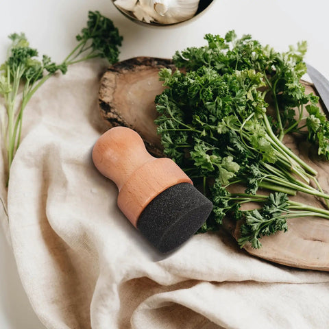 Straight Up Amazing Wooden Cutting Board Oil Brush And Built Tough Wood Wax Applicator Sponge on a kitchen towel with herbs.