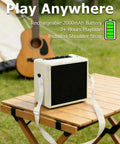 Cream white mini electric guitar amplifier with OTG recording on a table outdoors, showing shoulder strap and USB C connectivity.