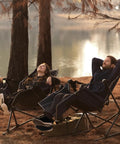 Two adults relax by a lake in Go Horizon Hammock Chair For Adults Up To 400 Lbs, Lie Flat Folding Camping Chair