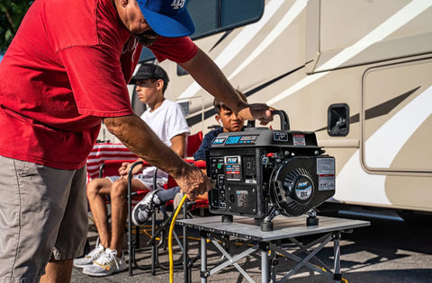 Man using gas powered portable generator with carrying handle 1200W running power and 1200 peak watts black and gray at a campsite.