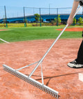 Person using Aluminum Maintenance Rake With Adjustable 66 To 98 Inch Handle, 36 Inch Lawn And Garden Landscape Rake for baseball field prep.