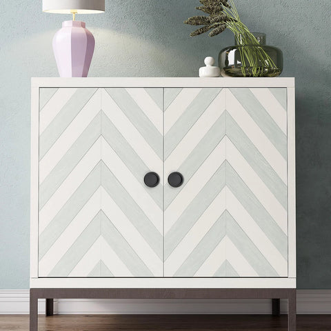 Chevron-patterned cabinet with black knob handles, decorative top items, and wooden flooring background.