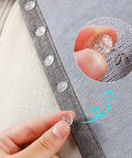 Close-up of hand using bed skirt twist pin with clear head for upholstery and slipcovers, demonstrating secure hold on fabric.