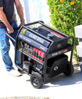 Person moving a 14,000 Watt Dual Fuel Portable Inverter Generator With Remote Electric Start Gas Or Propane on concrete path