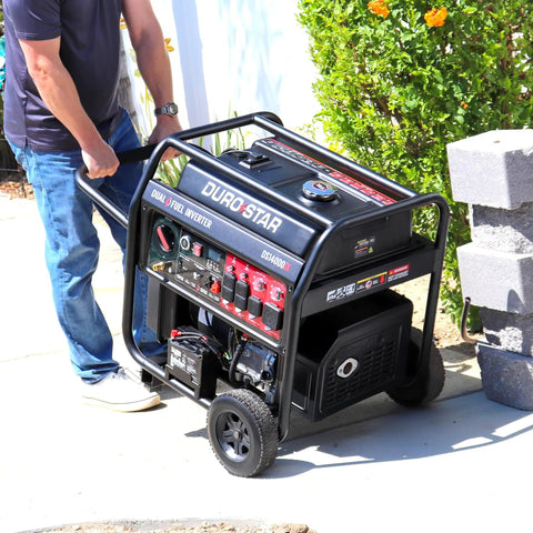 Person moving a 14,000 Watt Dual Fuel Portable Inverter Generator With Remote Electric Start Gas Or Propane on concrete path