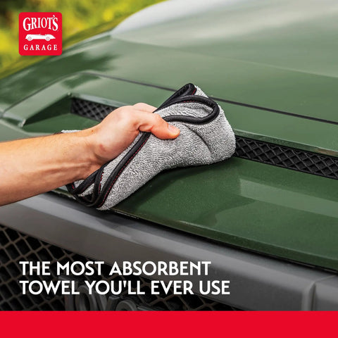 Person using Terry Weave Microfiber Towel for Super Fast Drying and Scratch Free Car Detailing on green car hood, 16 by 16 inch.