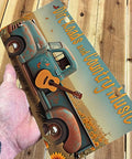 Hand holding Rustic Country Truck License Plate Sign with Guitar Motif, vintage pickup wall art, 12x6 inch metal decor.