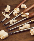 Badass Five Piece Wood Turning Lathe Chisel Set Featuring Rock Solid Tungsten Carbide Tips And Built Tough Square Stainless Handles with wood shavings.