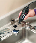 Hand using rotary tool with Tungsten Carbide Cutter Bit For Metal Glass Stone Engraving And Hard Wood Rotary Tool Carving Bits in sink area.
