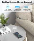 Recessed Power Strip Two Pack Desk Grommet Outlet 2.5 Inch Ten Foot Cord Triple USB Fast Charging Hub One AC Socket White Flush Desktop Charger installed on a gray table with a plant and phone.