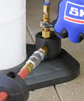 Close-up of Venturi Vacuum Pump Fluid Evacuator pneumatic connections and air shut off valve with glove for operation.