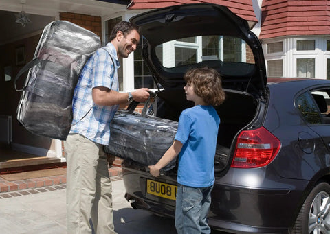 Man loading car with Heavy Duty Moving Bags 8 Pack Extra Large Storage Totes With Backpack Straps Strong Handles And Zippers Clear See Through Ideal Alternative To Moving Boxes Packing And Moving Supplies