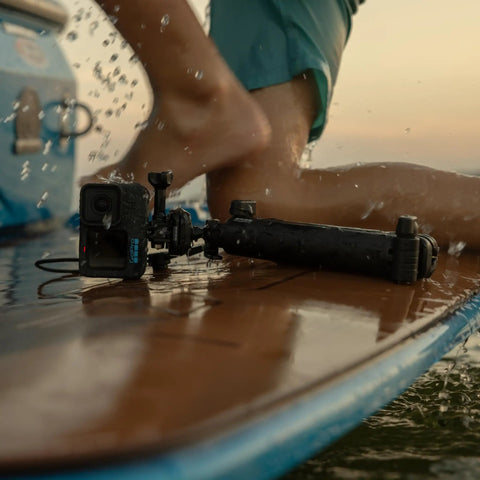 Premium Waterproof Action Camera Bundle With 5.3K60 Video And 27Mp Photos on a surfboard with splashing water.