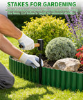 Person installing Flexible Landscape Edging Kit 59 Feet With 16 Extra Long Stakes 6 Inch Tall Plastic Border For Yard And Garden Bend To Curves Cut To Fit Weatherproof UV Resistant HDPE Ideal For Flower Beds And Tree Rings And Walkways along a flower bed with gloves and hammer