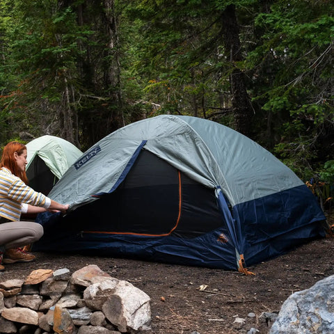 Person setting up Late Start 2P Backpacking Tent for Two People, Lightweight Camping Shelter with Quickcorner Pole Sleeves in forest