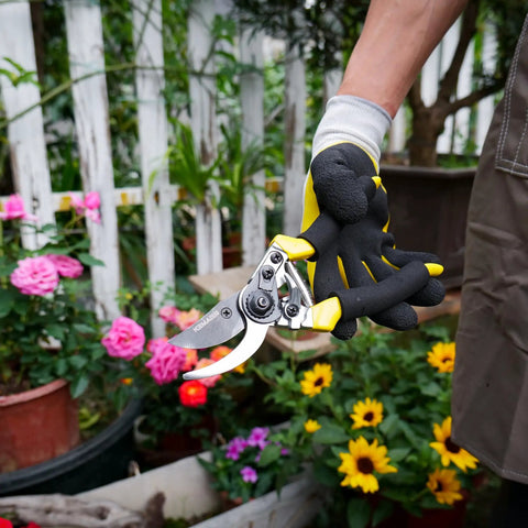 Gardener holding Pro Grade Pruning Shears For Gardening With Non Slip Ergonomic Handles And Blade Cover in a flower garden