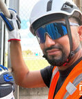 Worker wearing Badass Semi Frameless Safety Glasses With Ansi Z87 Certified features, blue mirrored lenses, and hard hat.