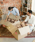 Couple using Top Tier Honeycomb Packing Paper Bubble Wrap Alternative For Moving Supplies Stretchy Kraft Cushion Roll in boxes.