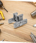 Front view of TEHAUX concealed stainless steel door hinge on wooden workbench; heavy-duty indoor/outdoor use
