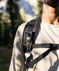 Close-up of man wearing Wakizashi Tactical Backpack 24L with MOLLE system, black, in outdoor setting.