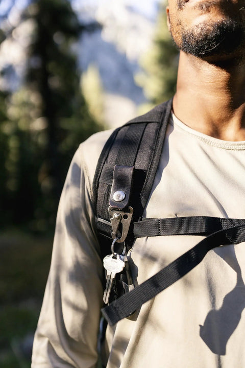 Close-up of man wearing Wakizashi Tactical Backpack 24L with MOLLE system, black, in outdoor setting.