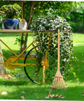 Portable Garden Hand Rake With Wear Resistant Tines next to a bike planter in a garden setting