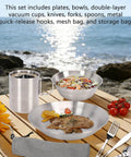 Camping Tableware Set For Four With Stainless Steel Mess Kit on wooden table by sea, with utensils and insulated cup.