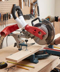 Heavy Duty Red Dust Hood For Machinery And Automatic Dust Collection Systems attached to a miter saw, capturing sawdust during cutting.