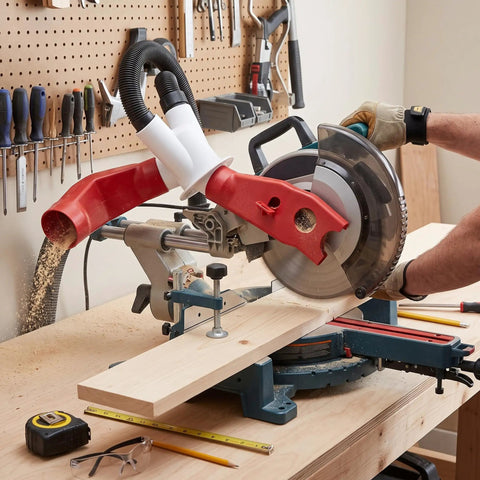 Heavy Duty Red Dust Hood For Machinery And Automatic Dust Collection Systems attached to a miter saw, capturing sawdust during cutting.