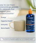 Straight Up Liquid Trace Mineral Drops Loaded With Seventy Plus Ionic Minerals And Key Electrolytes Like Magnesium Potassium And Chloride For Prime Body Function And Real Daily Vitality with a cup on table.