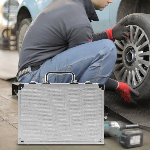 No Sweat Rolling Aluminum Toolbox With Handle Compact Storage Suitcase used while changing a tire in a garage.