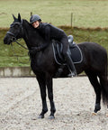 Adepto Quilted Quick-Dry Dressage Saddle Pad For Horses with Two-Tone Trim on black horse during outdoor riding session