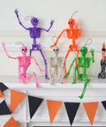 Spooky Hanging 16 Inch Posable Skeleton Set For Halloween Decor arranged on mantel, five colorful posable skeletons in festive pose.