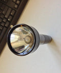 Bulletproof Heavy Duty C Cell Flashlight With Adjustable Beam and Quick Hands Free Candle Mode, top view on a desk.