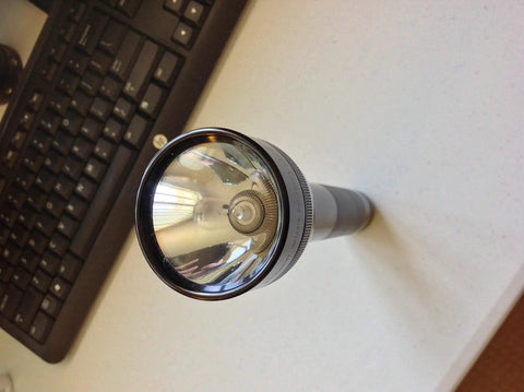 Bulletproof Heavy Duty C Cell Flashlight With Adjustable Beam and Quick Hands Free Candle Mode, top view on a desk.