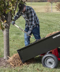 Workhorse Tow Behind Dump Cart With 750 Lb Capacity And Removable Tailgate For Yard Work next to tree being used for mulch